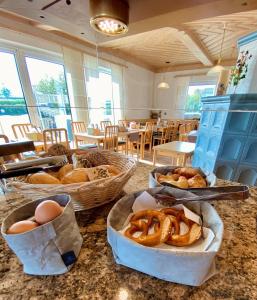 a table with baskets of bread and eggs on it at Hotel garni Kleindienst in Ursensollen
