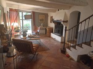 a living room with a staircase and a fireplace at la villageoise, chambre troglodyte pitoresque au cœur du village in Rognes