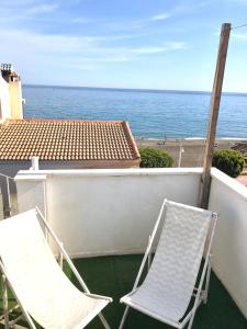 - deux chaises sur un balcon avec vue sur l'océan dans l'établissement Ático en la playa con terraza privada, à Cala del Moral