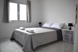 una camera bianca con un letto con due asciugamani di Villetta del mare corfu a Perivólion