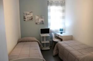 pokój z dwoma łóżkami i biurkiem z komputerem w obiekcie B&B Al Porticciolo w mieście Marsala