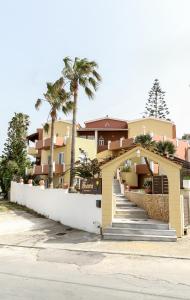 a building with an arch and palm trees at Heaven Apartments in Agia Marina Nea Kydonias