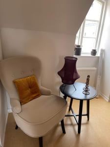 a chair and a table with a lamp in a room at Kristianstad Guest House in Kristianstad +20 photos