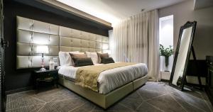 una camera da letto con un letto grande con una grande testiera di 21st Floor Hotel a Gerusalemme