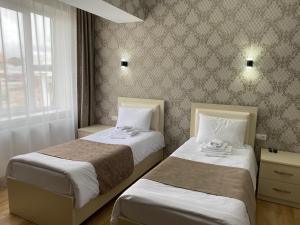 Hotel Sharl في Ninotsminda: غرفة نوم بسريرين ونافذة