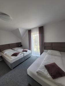 a bedroom with two beds and a window at Villa Fala in Dziwnówek