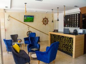 a waiting room with blue chairs and a bar at Hotel Palma Jaz Budva in Budva