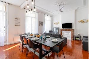 - un salon avec une table et des chaises noires dans l'établissement LE PRIVILIANE - Bel et grand appartement idéalement situé, à Marseille
