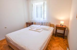 a small bedroom with a white bed and a window at House Sun and Sea in Olib