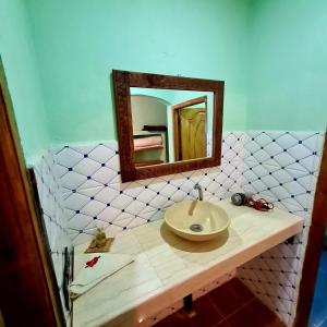 a bathroom with a sink and a mirror at Riad Hotel Les Flamants in Merzouga
