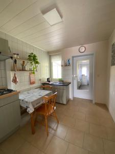 GutowにあるAm Ankerのテーブルと壁に時計があるキッチン +8枚の写真