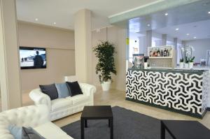 a living room with two white couches and a counter at Hotel Airone in Marina di Pietrasanta