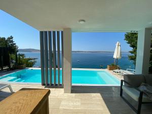 a swimming pool with a view of the ocean at VILLA OD MOORE STARIGRAD in Starigrad-Paklenica