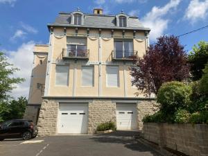 uma casa com duas portas de garagem e um carro estacionado na frente em Demeure des Dentelles em Le Puy-en-Velay