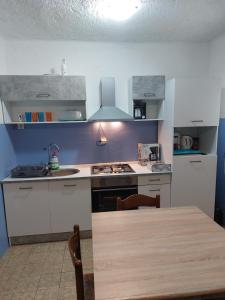 a kitchen with a table and a stove top oven at APARTMAN VERA in Cres