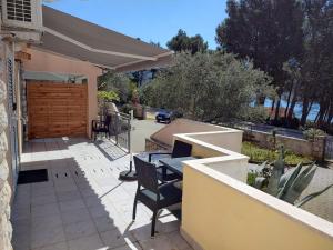a patio with a table and chairs and an umbrella at APARTMAN VERA in Cres