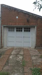 un garage avec deux portes de garage dans un bâtiment en briques dans l'établissement Monoambiente de la Costa, à Victoria