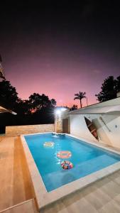 波多韋柳的住宿－Pousada nossas Raízes，夜间房子后院的游泳池