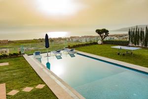 a large swimming pool with chairs and a table at Villa Agadir Taghazout Bay Beach & Golf View in Taghazout