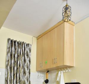 a cupboard in a kitchen with a curtain at Ruby Modern Homes Studio Apt-Imara Daima Behind Imaara Mall-JKIA-Nebula in Nairobi