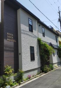 um edifício branco com um sinal na lateral em Nara Deer Hostel- - 外国人向け - 日本人予約不可 em Nara