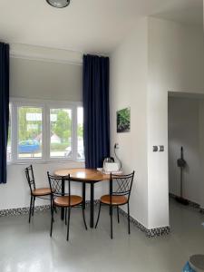 einen Tisch und Stühle in einem Zimmer mit Fenster in der Unterkunft Pisztráng17 Apartman in Gárdony