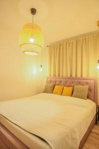 沙莫林的住宿－Residence Šamorín，卧室配有一张带黄色枕头的大型白色床。