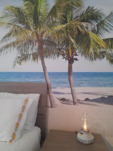een kamer met een tafel en palmbomen op het strand bij Casa Laura in Terracina