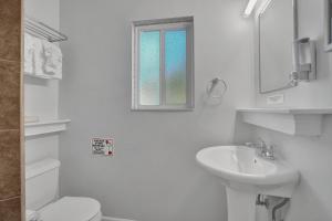 a white bathroom with a toilet and a sink at The Worthington Resorts - Clothing Optional - Men Only - Solo hombres in Fort Lauderdale