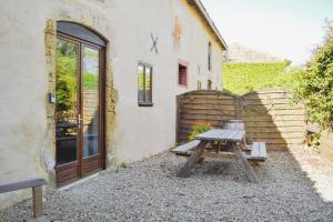 a wooden picnic table in front of a building at La Grange @ Le Prielle in Madiran