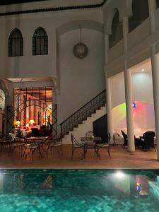 a house with a swimming pool and a living room at Riad Chergui in Marrakech