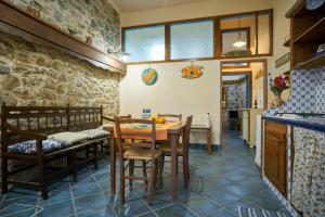a kitchen and dining room with a table and chairs at Pietra di mare in SantʼAgata di Militello