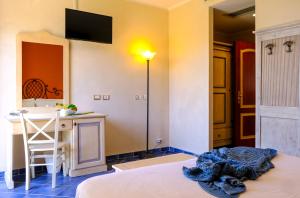a room with a bed and a table and a counter at Hotel Baglio Di Scopello in Scopello