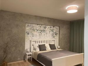 1 dormitorio con 1 cama con un mural floral en la pared en Family Provence Mikulov en Mikulov