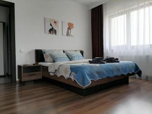 a bedroom with a bed with a blue comforter at Aparthotel Laura in Cluj-Napoca