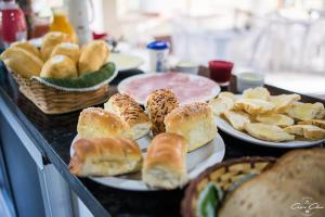 a table topped with plates of bread and pastries at Pousada Vale das Orquídeas in Lavrinhas