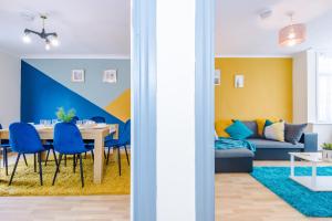 ein Esszimmer und ein Wohnzimmer mit einem Tisch und blauen Stühlen in der Unterkunft 5 Bedroom House By NYOS PROPERTIES Short Lets & Serviced Accommodation Manchester With Free WiFi in Birmingham