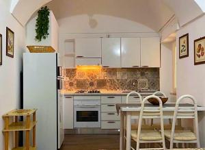 Una cocina con un refrigerador blanco y una mesa y sillas. en Fenì Home, en Tricarico 22 fotos más