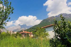 a building in front of a mountain with mountains at Casa da Ste in Mandello del Lario