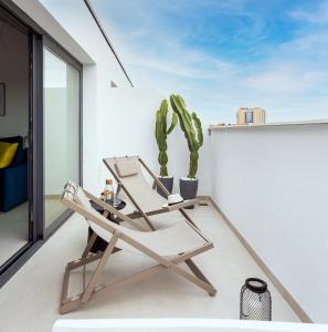 a chair on a balcony with a cactus at Caleyro Boutique Apartments - "Parking incluido" in Fuengirola