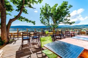 een terras met tafels en stoelen en uitzicht op het water bij Le Nesk Ventoux - Hotel in Sault-de-Vaucluse