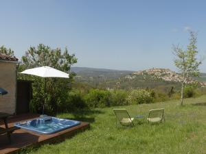 patio z 2 krzesłami i parasolem w obiekcie Détente à Cordes-sur-ciel, vue magnifique, SPA w mieście Souel-et-Sarmases