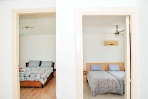 a bedroom with two beds and a hallway with two beds at Crystal Bay View Apartment in Kalogrea