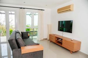 a living room with a couch and a flat screen tv at Crystal Bay View Apartment in Kalogrea