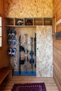 a room with a wall full of ski equipment at Chalet premium -Accès pied de piste en navette in Saint-Chaffrey