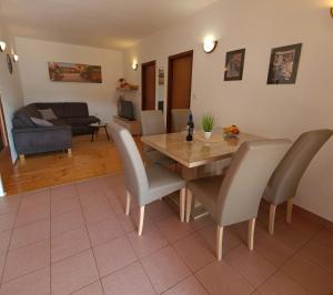 Un comedor y una sala de estar con mesa y sillas. en Apartments Radović, en Labin