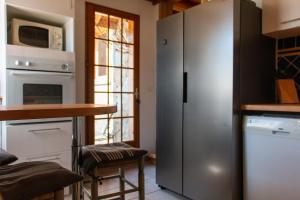 eine Küche mit einem Kühlschrank aus Edelstahl und einem Tisch in der Unterkunft Chalet premium -Accès pied de piste en navette in Saint-Chaffrey