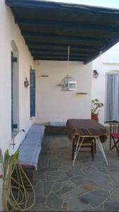 eine Terrasse mit einem Tisch, einer Bank und einer Decke in der Unterkunft Apartment in the center of Artemonas, Sifnos in Artemonas