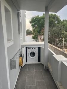 a washer and dryer in a balcony with a washing machine at Ether in Perivolos