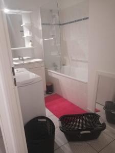 La salle de bains est pourvue d'une baignoire, d'un lavabo et d'une douche. dans l'établissement appartement meublés, à Coutances